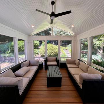 Bright three season room with vaulted ceiling and wicker seating