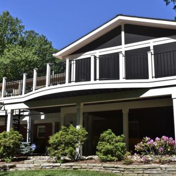 Large elevated deck with black railings and covered space below
