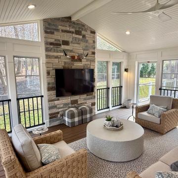 Bright three season room with stone fireplace and vaulted beadboard ceiling