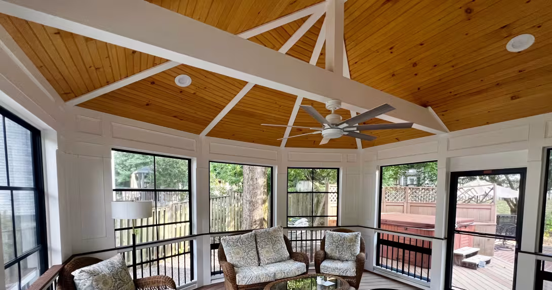 Screened porch with wood vaulted ceiling, beams, and ceiling fan